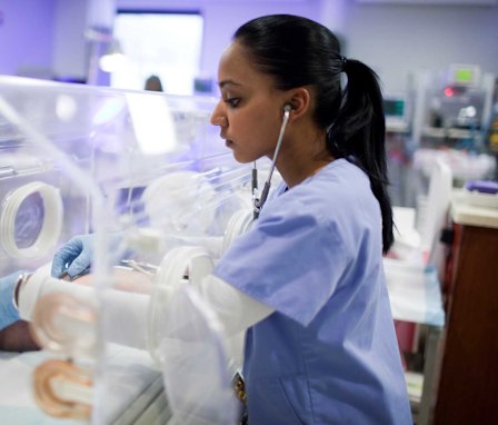 Neonatal nurse checking newborn's heartbeat