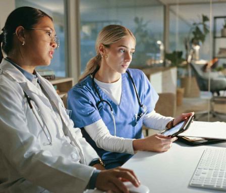 Nurse and doctor looking at computer together