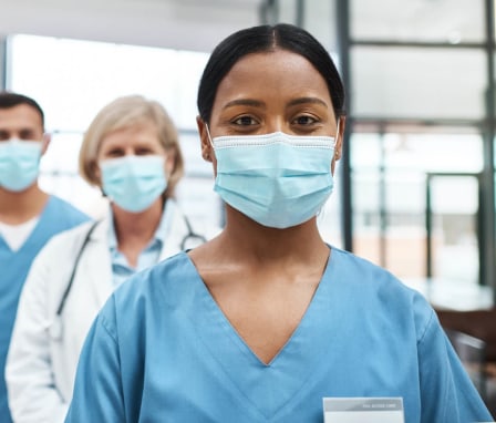 Medical practitioners wearing face masks while standing together in a hospital