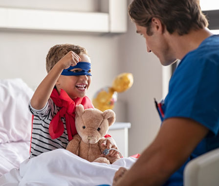 Pediatric nurse helping a kid dressed as a superhero