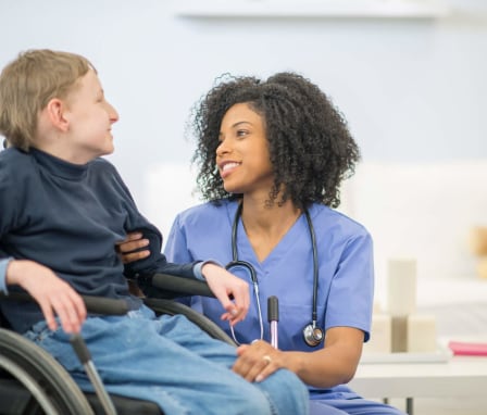 Nurse assisting disabled child