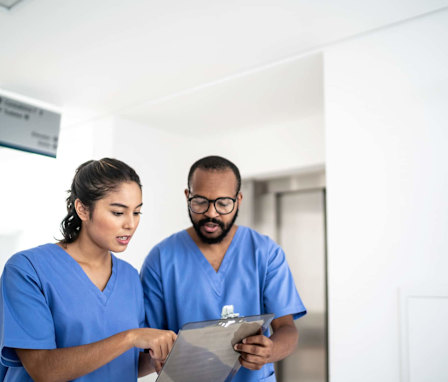 Nurses walking and talking at corridor hospital
