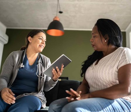 Nurse speaking to woman in her home