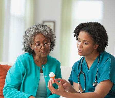 Home nurse helping patient with medication
