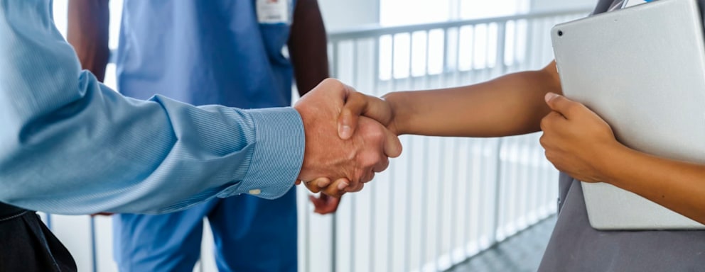 Nurse shaking hands with business professional