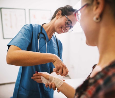 Wound care nurse helping patient with her hand